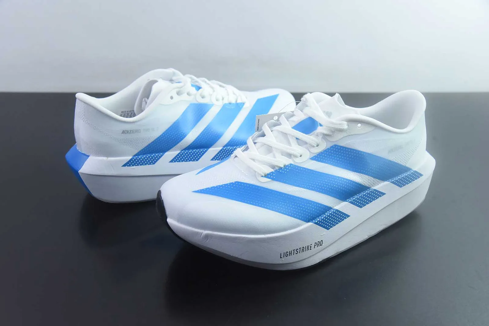 adidas Adizero Evo SL 2 na colorway Cloud White / Blue Bird (branco com as três riscas e pormenores no calcanhar em azul-claro/brilhante)