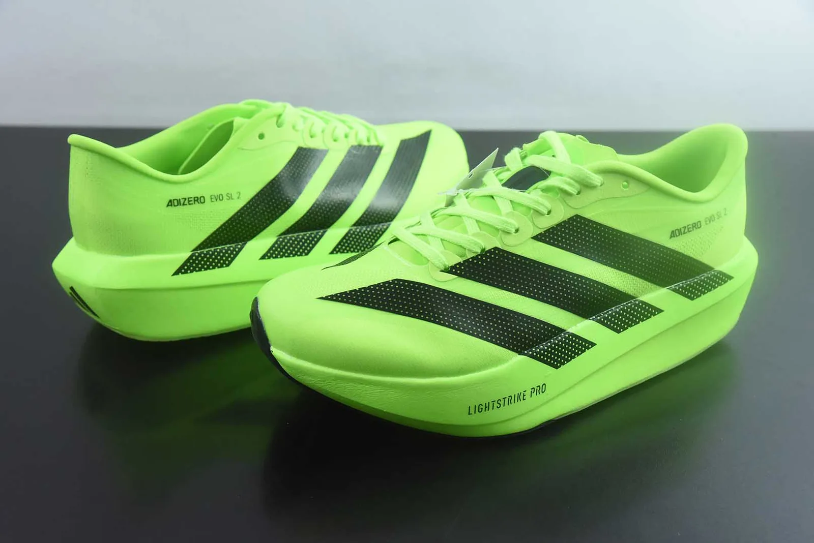 adidas Adizero Evo SL 2 (ou Adizero Adios Pro Evo) na colorway Lucid Lemon / Core Black (verde-lima / amarelo-vibrante com as três riscas em preto)