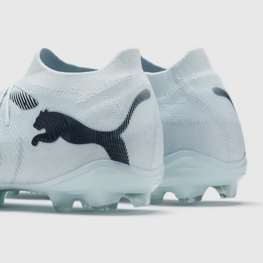 Puma Future Ultimate FG/AG (em tom branco/cinza-claro com o logótipo da Puma em preto e detalhes texturizados).